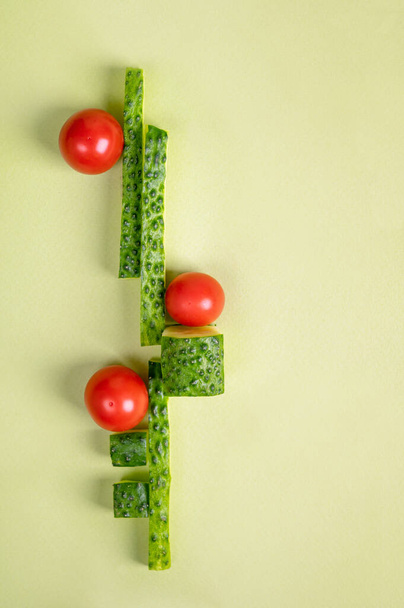 Vegetable art composition. Abstract balancing construction of sliced cucumber and tomatoes. Copy space. Modern visual art, minimal design, healthy food concept. - Zdjęcie, obraz