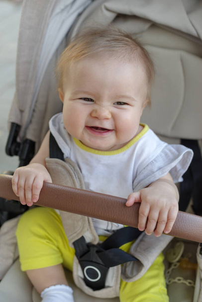 Primer plano de linda niña en cochecito de bebé al aire libre - Foto, imagen