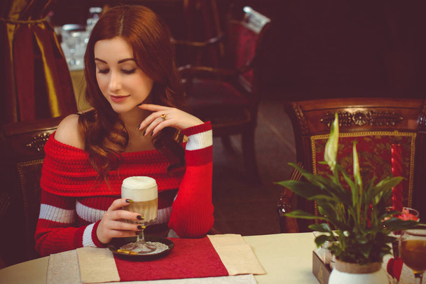 Image of serene girl sitting in cafe and thinking about something. Lady with coffee in restaurant. Stylish glamorous lady at vacation. Retro style. Concept of women's secret - Foto, immagini