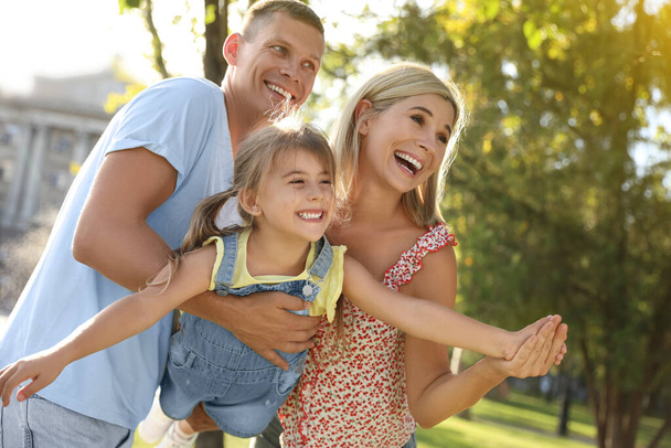 Happy parents with their child having fun outdoors. Spending time in nature - Photo, image