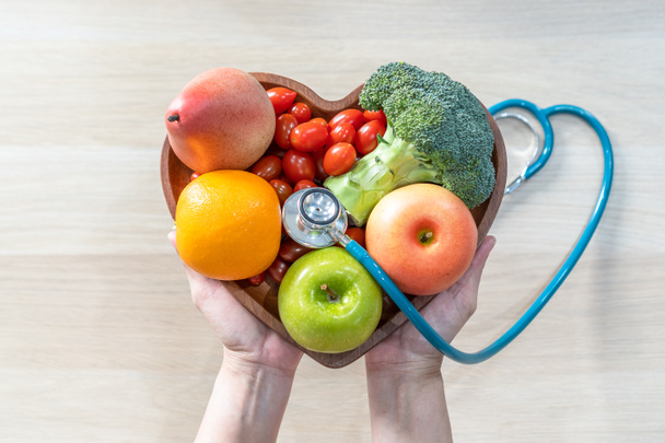 Питательная пища для здоровья сердца оздоровительный холестерин диета и здоровое питание едят с чистыми фруктами и овощами в блюдо сердца диетолога и врача рекомендуется для благополучия пациента  - Фото, изображение