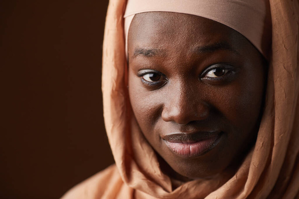 Close up portrait of ethnic African-American woman wearing headscarf and looking at camera while posing in studio, copy space - Photo, Image