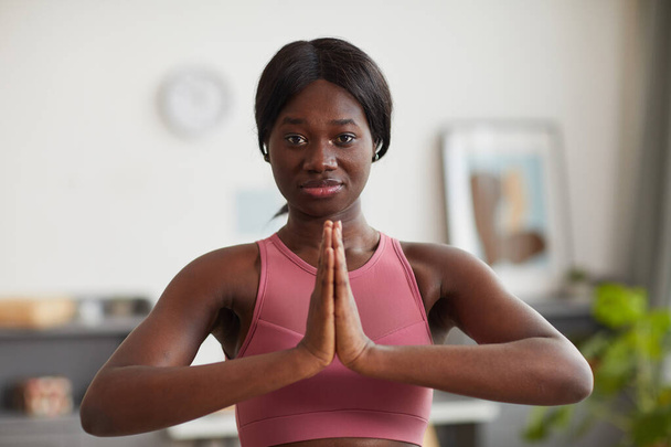 Portret młodej Afroamerykanki oglądającej kamerę podczas treningu jogi i odnowy biologicznej w domu - Zdjęcie, obraz