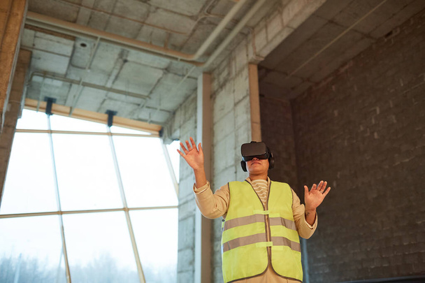 Laaja kulma muotokuva naisinsinööri yllään VR kuulokkeet päällä, kun visualisoidaan rakennusprojekti, kopioi tilaa - Valokuva, kuva