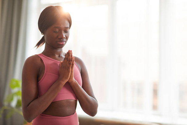 Ritratto in vita di donna afro-americana serena che fa yoga o medita a casa durante la pratica del benessere, copiare lo spazio - Foto, immagini