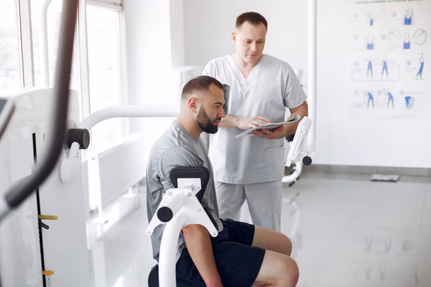 Doctor with a patient in physiotherapy clinic - Foto, Bild