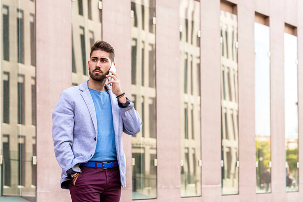 Cheerful modern businessman speaking by phone and smiling while standing outdoors - Foto, Imagem