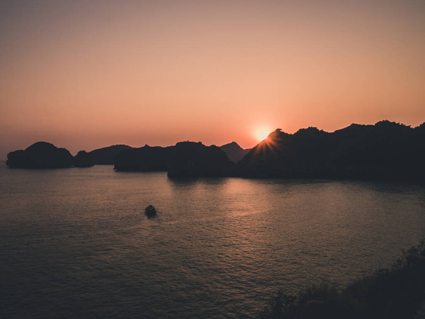 Beautiful sunset, fishing boat, rocky islands. Halong Bay. Toned - Valokuva, kuva
