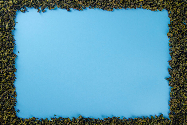 Mavi arkaplanda, metin için yeri olan kuru çay yaprakları çerçevesi - Fotoğraf, Görsel