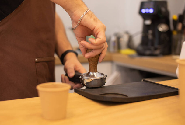 partial view of male barista in apron making coffee in coffee shop - Foto, Bild