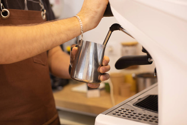 partial view of male barista in apron making coffee in coffee shop - Foto, Bild