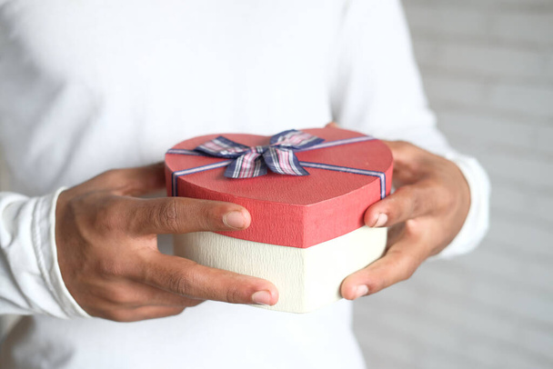 man hand holding a gift box close up  - Фото, изображение