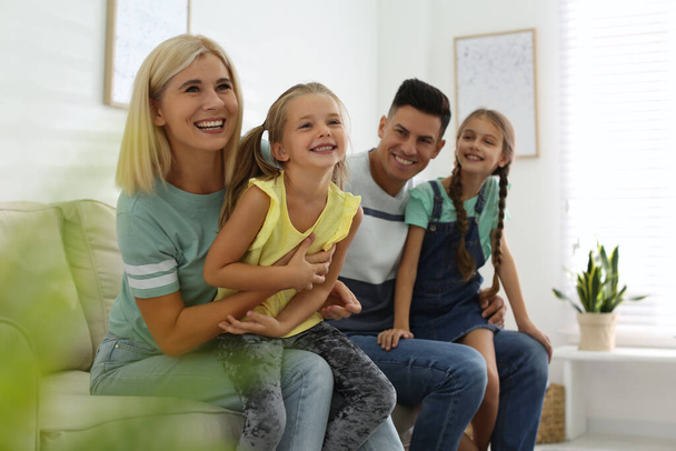 Happy family with children on sofa indoors - 写真・画像