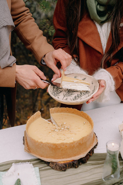 Hands cut a wedding cake in autumn - Фото, зображення