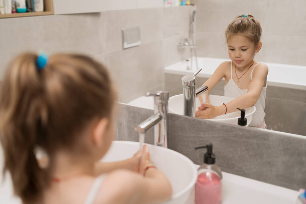 klein meisje wassen handen met zeep - Foto, afbeelding