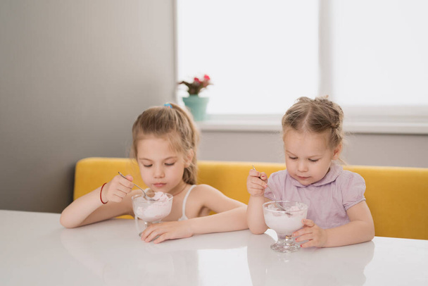 テーブルの上でアイスクリームを食べる女の子 - 写真・画像