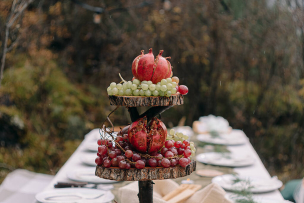 Plate with pomegranates and grapes in autumn - Fotoğraf, Görsel
