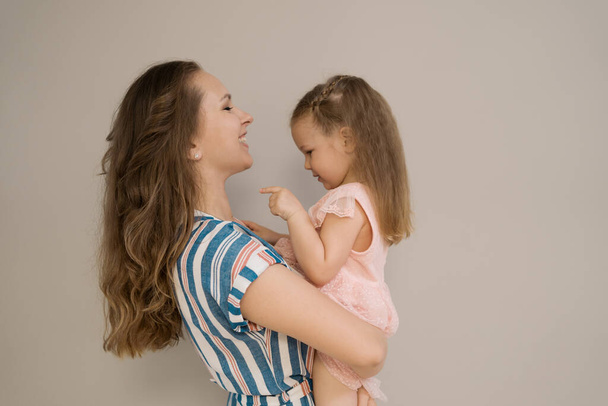 Mother and daughter portrait on beige background - Photo, Image