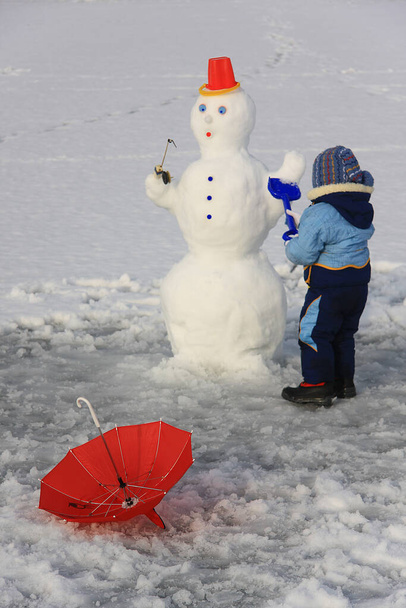 bambino in abiti invernali facendo un pupazzo di neve - Foto, immagini