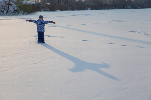新雪の中で遊んでいる少年が - 写真・画像