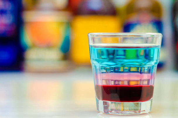 Una bebida en capas de colores en un bar preparado por el camarero, tiempo de fiesta - Foto, Imagen