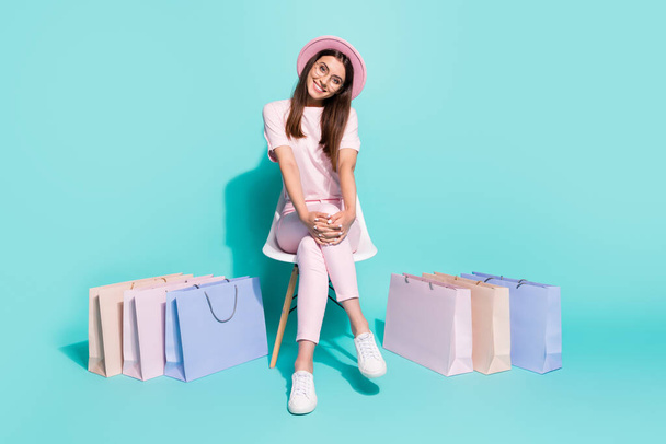 Portrait of her she nice-looking attractive pretty cute cheerful cheery girl fashionista sitting in chair among bags new clothes isolated on bright vivid shine vibrant green turquoise color background - Fotografie, Obrázek