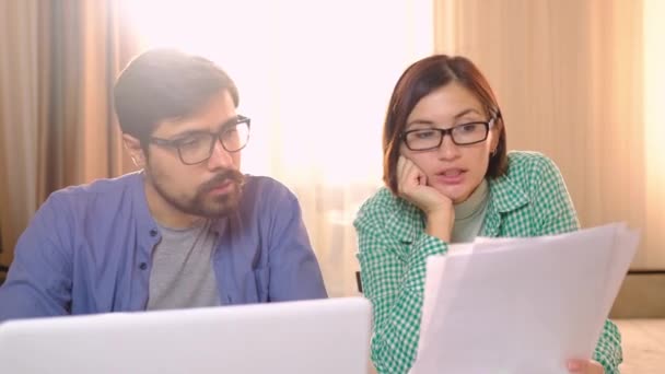 Серьезные молодые супруги оплачивают счета онлайн - Кадры, видео