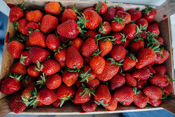 Ripe fresh strawberries close-up in a container for sale. Healthy diet - Foto, immagini