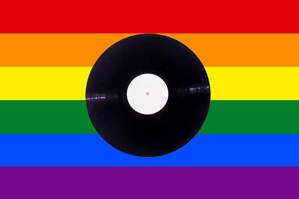 Grabación de vinilo musical sobre fondo de bandera de color arco iris lgtb con etiqueta blanca - Foto, Imagen