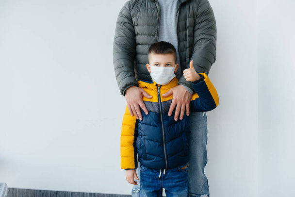 Um pai com seu filho está em uma máscara durante a quarentena. Pandemia, coronavírus - Foto, Imagem