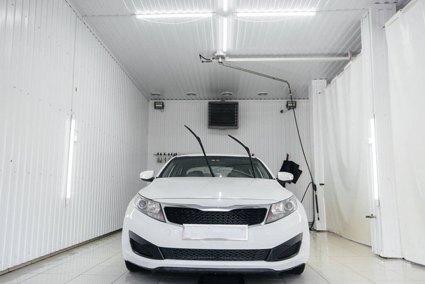 Modern washing with foam and high-pressure water of a white car. Car wash - Foto, immagini