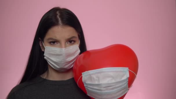 Coronavirus sosyal mesafe konsepti. Koruyucu maskeli kadın ve balon kalp - Video, Çekim