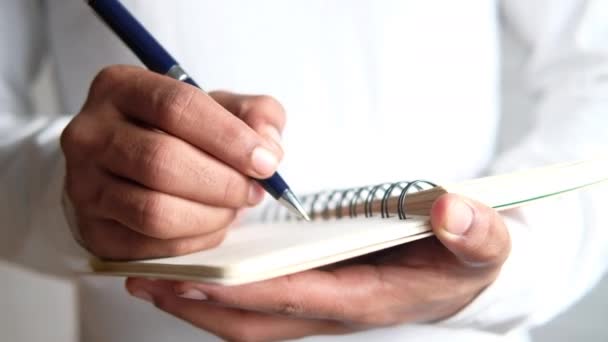 Close-up van de man hand schrijven op notitieblok. - Video