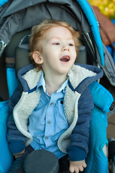 Niño de cuatro años con parálisis cerebral sentado en el asiento del coche - Foto, Imagen