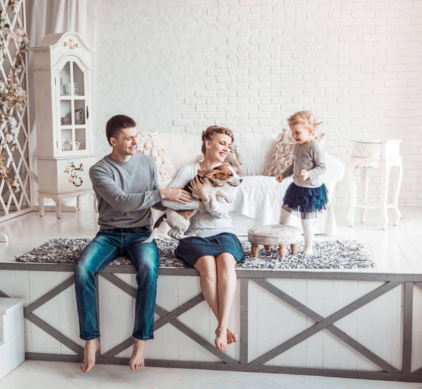 portrait of a happy family and their pet in a cozy living room - Foto, Imagen