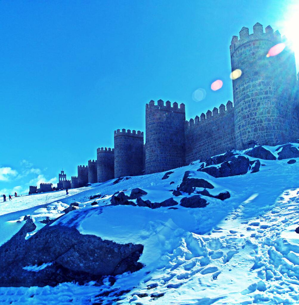 Średniowieczny Mur Avila w Hiszpanii i jego Śnieżny Stok oraz ludzie bawiący się śniegiem w słoneczny dzień. - Zdjęcie, obraz