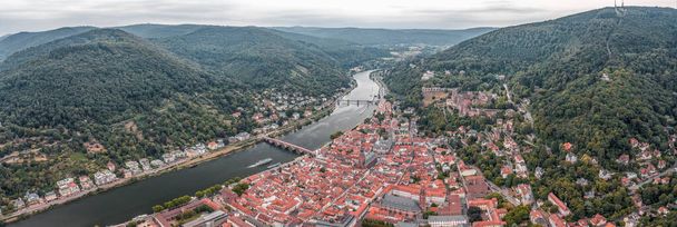 Drone aérien panoramique de la vieille ville d'Heidelberg dans un ciel couvert au pied de la montagne Konigstuhl - Photo, image