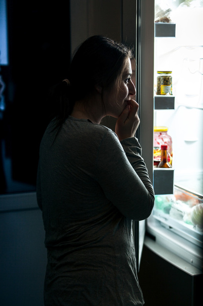 Nainen pyjamassa avaamassa jääkaappia yöllä
 - Valokuva, kuva