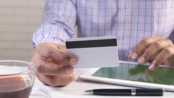 Hombre mano celebración de la tarjeta de crédito y el uso de tabletas digitales de compras en línea  - Metraje, vídeo