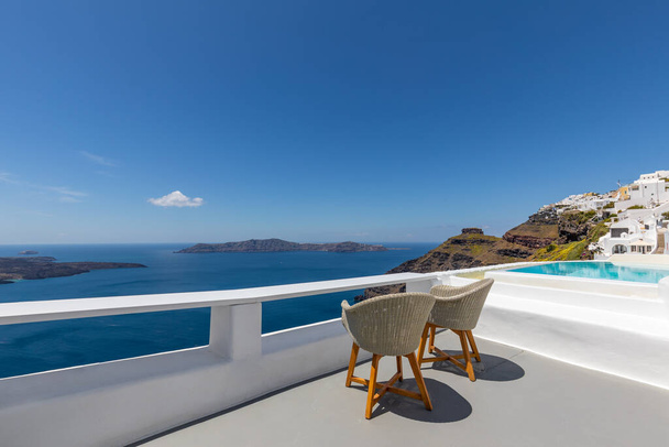 Valkoinen arkkitehtuuri Santorinin saarella, Kreikassa. Rentoudu yli Caldera näkymä sininen meri, aurinkoinen sininen taivas. Ylellinen kesäloma, loma. Tuolit pariskunnille, romanssi, rakkaus, häämatka kohde - Valokuva, kuva