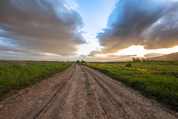 Country road with fields under dramatic sky backgroun - Foto, Imagem