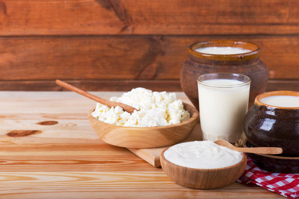 Молочні продукти на дерев'яному столі на синьому фоні. молочні сільські продукти на дерев'яному столі
 - Фото, зображення