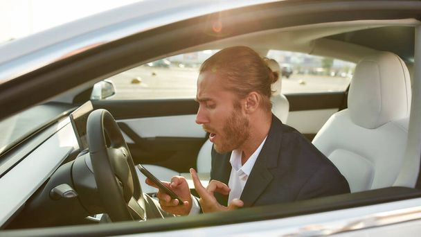 Angry businessman talking on mobile phone in car - Photo, Image