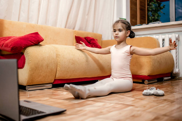 Jeune ballerine pratiquant la chorégraphie classique pendant les cours en ligne à la maison, auto-isolement - Photo, image