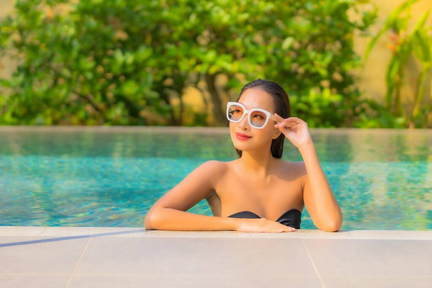 Portrait beautiful young asian woman enjoy relax around swimming pool for leisure vacation - Foto, Imagem