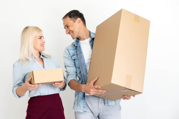 moving, home and family concept - smiling couple holding cardboard boxes - Photo, Image