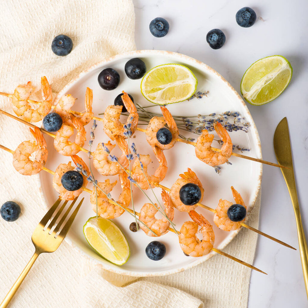 shrimp on skewers with lavender and blueberries, gourmet cuisine - Photo, Image