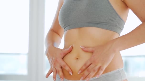 A nő bemocskolja a gyomrát terhességi csíkokkal géllel és masszírozza magát. - Felvétel, videó