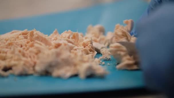 Chef cuts boiled chicken fillet on a blue plastic board - Footage, Video