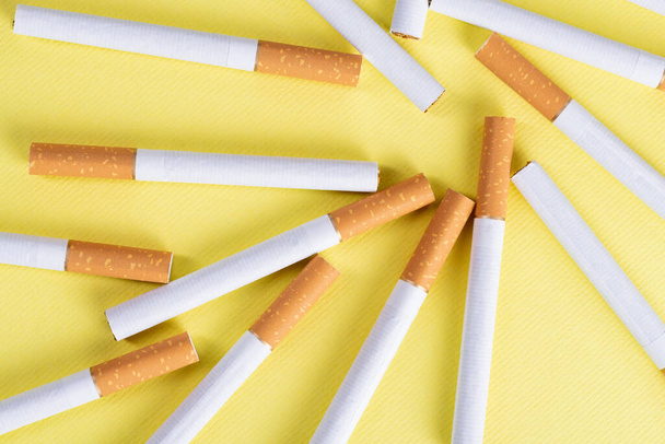 Lots of industrial cigarettes on a yellow background. - Foto, Bild